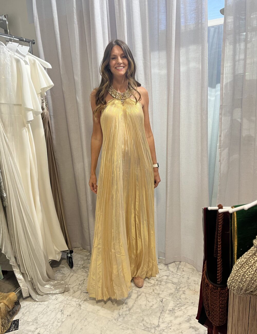 Model wearing one of a kind gold lame pleated halter gown with crystal beaded neckline